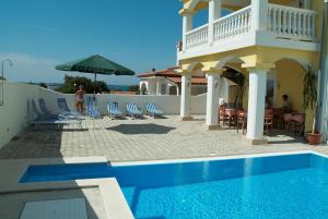 een villa met een zwembad en een huis bij Triple Room Peroj 2235f in Peroj