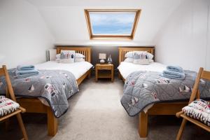 Un dormitorio con dos camas y una ventana. en Calliope House, en Whitby