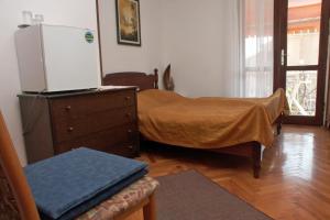 a bedroom with a bed and a dresser with a refrigerator at Rooms with a parking space Rovinj - 2245 in Rovinj