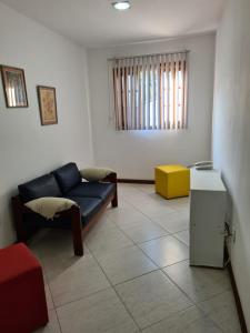 a living room with a blue couch and a yellow table at Residencial Gigoia Inn in Rio de Janeiro