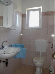 łazienka z toaletą, umywalką i oknem w obiekcie Apartments with a parking space Fazana - 2261 w Fažanie