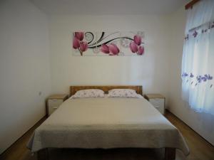 ein Schlafzimmer mit einem Bett mit rosa Blumen an der Wand in der Unterkunft Family friendly seaside apartments Cove Torac, Hvar - 2071 in Gdinj