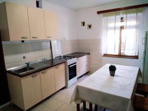 eine Küche mit einem Tisch, einer Spüle und einem Herd in der Unterkunft Family friendly seaside apartments Cove Torac, Hvar - 2071 in Gdinj