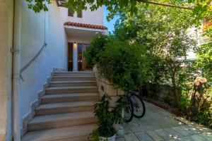 ein Fahrrad, das an der Seite eines Hauses mit Treppe geparkt ist in der Unterkunft Apartments by the sea Jelsa, Hvar - 4017 in Jelsa