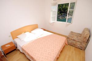 GdinjにあるSeaside secluded apartments Cove Torac, Hvar - 4044のベッドルーム1室(ベッド1台、椅子、窓付)