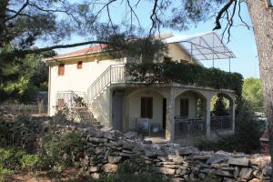 une maison avec un mur en pierre devant elle dans l'établissement Apartments with a parking space Mudri Dolac, Hvar - 4043, à Vrbanj