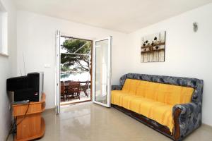 a living room with a yellow couch and a tv at Apartments by the sea Mudri Dolac, Hvar - 4026 in Vrboska