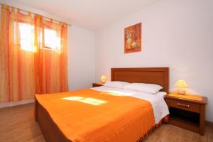 a bedroom with a large orange bed and a window at Apartments by the sea Mudri Dolac, Hvar - 4026 in Vrboska