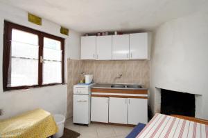 uma pequena cozinha com armários brancos e um lavatório em Secluded fisherman's cottage Cove Skozanje, Hvar - 4039 em Gdinj