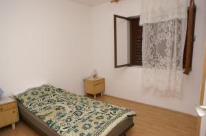 niewielka sypialnia z łóżkiem i oknem w obiekcie Apartments with a parking space Jelsa, Hvar - 4040 w mieście Jelsa