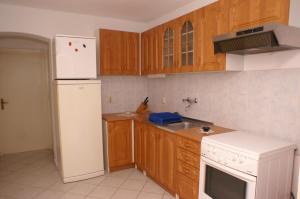 - une cuisine avec des placards en bois et un réfrigérateur blanc dans l'établissement Apartments with a parking space Jelsa, Hvar - 4040, à Jelsa