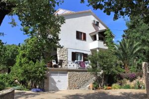 a white house with a balcony and trees at Apartments with a swimming pool Stari Grad, Hvar - 4015 in Stari Grad