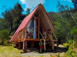 ein kleines Haus mit rotem Dach in der Unterkunft Dante Glamping in Guatavita