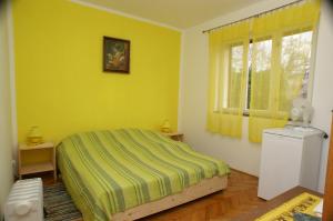 Dormitorio amarillo con cama y ventana en Rooms by the sea Jelsa, Hvar - 4041, en Jelsa