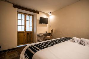 波哥大的住宿－The Luun Hostel，一间卧室配有一张床、一张书桌和一个窗户。