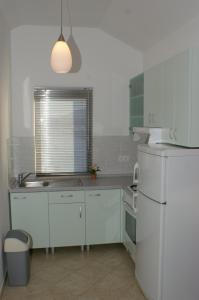 a white kitchen with a sink and a refrigerator at Apartments with a parking space Stari Grad, Hvar - 4014 in Stari Grad