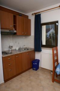 a kitchen with wooden cabinets and a sink and a window at Apartments with a parking space Stari Grad, Hvar - 4014 in Stari Grad