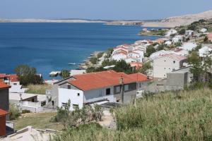 un grupo de casas en una colina junto al agua en Apartments with a parking space Metajna, Pag - 4127, en Zubovići