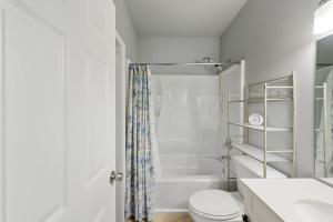 a white bathroom with a toilet and a shower at The Secluded Secret in Stone Mountain in Stone Mountain