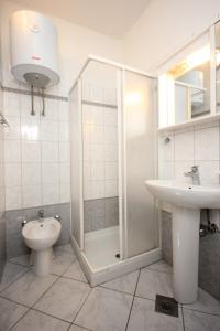 e bagno con doccia, servizi igienici e lavandino. di Holiday apartments Pjescana Uvala, Pula - 2218 a Vinkuran