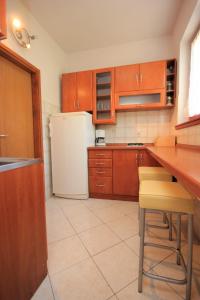 una cucina con armadi in legno e frigorifero bianco di Holiday apartments Pjescana Uvala, Pula - 2218 a Vinkuran