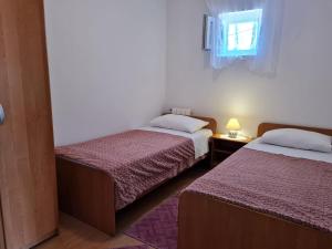 twee bedden in een kleine kamer met een raam bij Apartments with a parking space Lun, Pag - 4062 in Lun