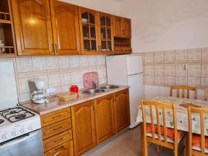 een keuken met houten kasten en een witte koelkast bij Apartments with a parking space Lun, Pag - 4062 in Lun