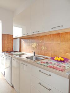 una cocina con fregadero y una barra con naranjas. en Apartments with a parking space Vlasici, Pag - 4139 en Vlašići