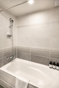 uma casa de banho com uma banheira branca e um chuveiro em G3 Hotel Chungmuro em Seul
