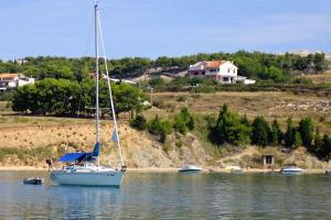 żaglówka w wodzie przed domem w obiekcie Family friendly seaside apartments Vlasici, Pag - 4131 w mieście Vlašići