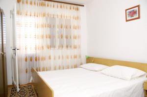 łóżko w pokoju z oknem w obiekcie Family friendly seaside apartments Vlasici, Pag - 4131 w mieście Vlašići
