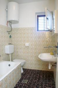 łazienka z umywalką, wanną i toaletą w obiekcie Family friendly seaside apartments Vlasici, Pag - 4131 w mieście Vlašići