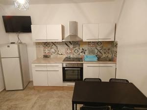 eine Küche mit weißen Schränken und einem Tisch mit Stühlen in der Unterkunft Apartment Metajna 4150b in Metajna + 12 Fotos