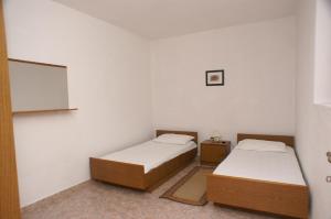twee bedden in een kamer met witte muren bij Apartment Novalja 4114d in Novalja