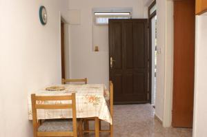 een kamer met een tafel en stoelen en een deur bij Apartment Novalja 4114d in Novalja
