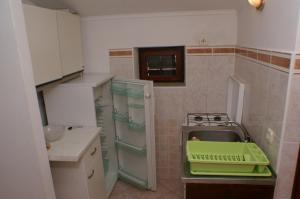 una piccola cucina con lavandino e piano cottura di Apartments and rooms by the sea Zubovici, Pag - 4065 a Zubovići