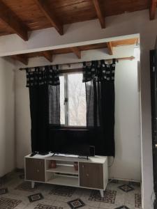 a living room with a tv and a window at Departamento Pájaro Carpintero in Ushuaia