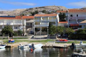 a group of boats on the water in front of buildings at Apartments by the sea Kustici, Pag - 4129 in Kustići