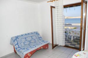 a room with a chair and a view of the ocean at Apartments by the sea Kustici, Pag - 4129 in Kustići