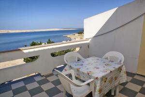 a table and chairs on a balcony with a view of the ocean at Apartments by the sea Kustici, Pag - 4129 in Kustići