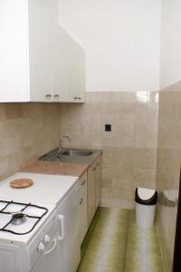 une cuisine blanche avec un évier et une cuisinière dans l'établissement Apartments with parking space Potocnica, Pag - 4096, à Stara Novalja 55 autres photos