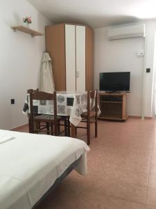 a bedroom with a bed and a tv and a table and chairs at Apartment Potocnica 4096f in Stara Novalja