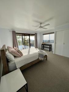 a bedroom with a bed and a large window at Waratah Holiday Home in Unanderra