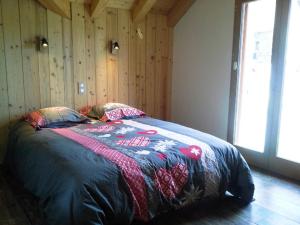 una camera da letto con un letto con una coperta sopra di Duplex 5 pièces, 10 pers, Sud, Animaux admis, Parking - FR-1-263-511 a Valloire