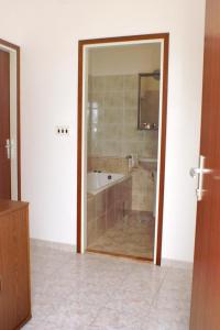 a bathroom with a tub and a shower with a mirror at Apartments by the sea Razanj, Rogoznica - 4253 in Ražanj