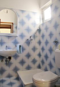 a blue tiled bathroom with a toilet and a sink at Apartments by the sea Razanj, Rogoznica - 4253 in Ražanj