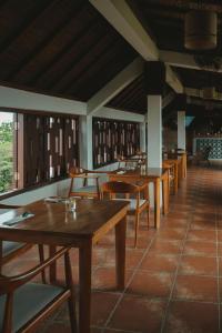 una fila di tavoli e sedie in un ristorante di The Visala Boutique Suites Seminyak a Seminyak