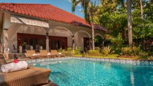 a swimming pool in front of a villa at Villa Kelapa in Lovina