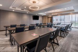 a conference room with tables and chairs and a tv at Vīb Hotel by Best Western Denver RiNo in Denver