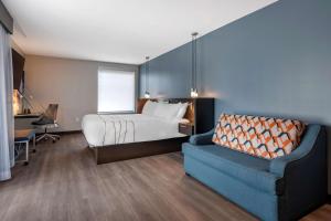 a bedroom with a bed and a couch and a chair at Vīb Hotel by Best Western Denver RiNo in Denver